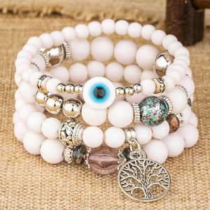 Mehrlagiges Perlenarmband mit Lebensbaum-Anhänger und blauem Auge-Akzent auf Sackleinen