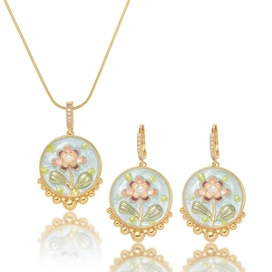 Detail of floral enamel jewelry set with necklace and earrings on white background