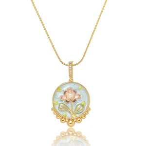 Detail of floral enamel pendant with freshwater pearl on a delicate gold chain