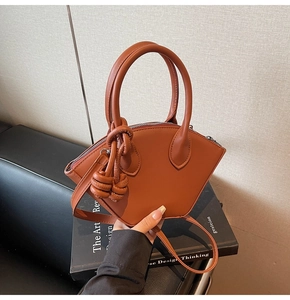 Borsa a conchiglia caramello con manico tondo, ciondolo a nodo e dettagli con zip