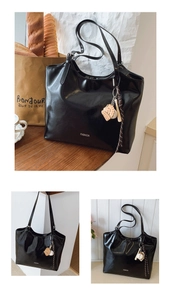 Detail der glänzenden schwarzen Tote Bag mit FASHION-Text und Baseball-Anhänger