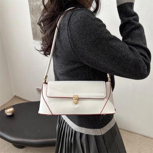 White baguette underarm bag with red piping and gold buckle shown on a model
