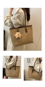 Detail view of khaki tote bag with dark brown straps and plush star charm accessory