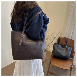 Detailansicht großer Vintage-Einkaufstaschen aus strukturiertem Leder in Braun und Schwarz