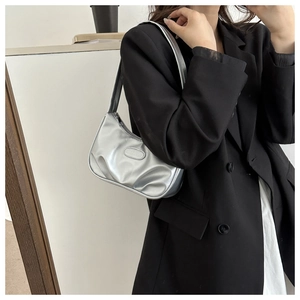 Détail du sac croissant argenté métallisé montrant la texture brillante et le logo