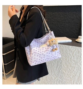 Dettaglio della borsa tote viola chiaro con stampe di fiocchi e ciondolo di peluche