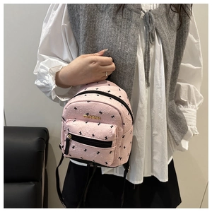 Pink mini backpack detail with textured pleated fabric and black butterfly print