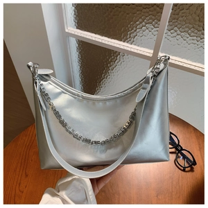 Detail of silver metallic hobo bag with thick strap and decorative metal chain