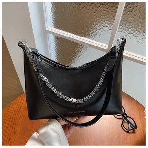Close-up of black PU leather underarm bag featuring a chunky silver metal chain and logo