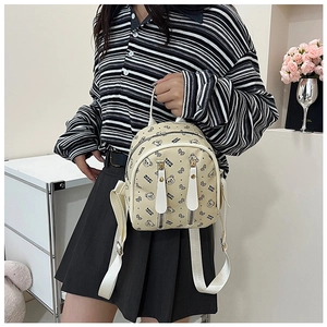 Détail du mini sac à dos crème avec motifs d'ours et bretelles réglables blanches élégantes