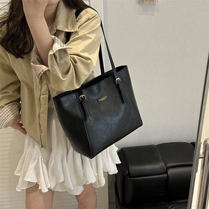 Minimalistische schwarze Tote Bag aus PU-Leder mit goldener Schnalle an Frauenmodel