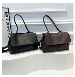 Minimalist black and brown PU leather tote bags shown in a clean indoor studio set