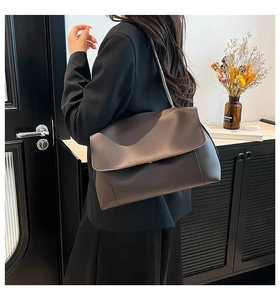 Model wearing a deep brown matte PU leather tote bag with a minimalist flap closure design