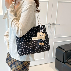 Borsa tote trapuntata nera con fiocchi rosa, tracolla bianca e ciondolo orsetto di peluche