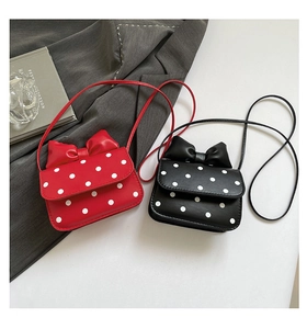 Close-up of cute polka dot mini shoulder bags with large bow detail and long straps