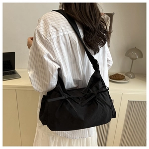Detail of black nylon shoulder bag with bow ribbons for casual daily commute