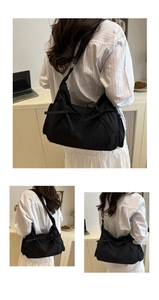 Detail of a large black tote bag featuring decorative bows and spacious hobo style