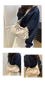 Detail of lightweight beige nylon shoulder bag with cute bow accents and pleated texture