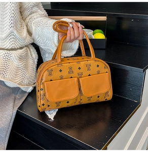 Detailed close-up of a caramel Boston bag with bear patterns and dual flap pockets