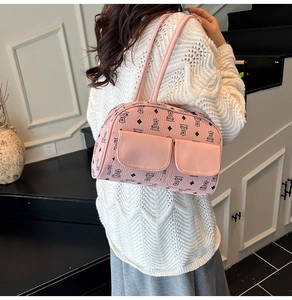 Close-up of pink leather shoulder bag featuring black and white bear patterns and pockets