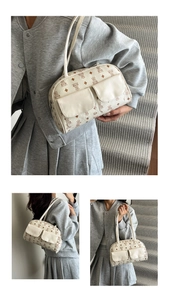 Detail view of beige Boston bag featuring cute bear prints and double front pockets