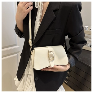 Sac bandoulière en cuir PU blanc cassé avec boucle dorée porté par un mannequin