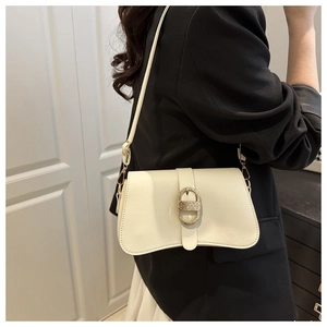 Off-white faux leather shoulder bag with textured gold buckle detail on a black blazer
