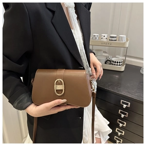 Détail d'un sac demi-lune marron avec boucle dorée texturée et finition en similicuir