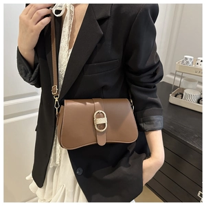 Gros plan du sac sous le bras en cuir marron avec boucle dorée sur un mannequin