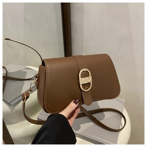 Vue détaillée du sac en cuir marron foncé avec boucle dorée en D et rabat texturé