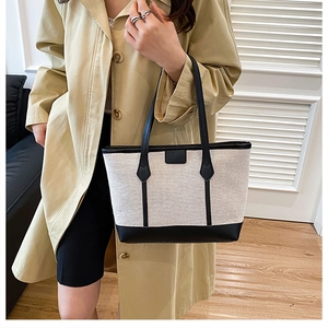 Détail du sac fourre-tout en toile avec finitions en cuir noir et texture premium