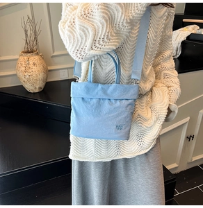 Gros plan du sac RAH TOP bleu clair en tissu Oxford avec logo embossé et bandoulière