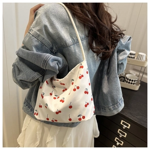 Sac croissant avec imprimé cerise porté en bandoulière sur une tenue décontractée