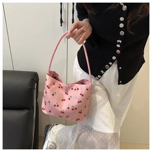 Gros plan sur le sac en nylon rose avec motif cerises rouges et fine bandoulière douce