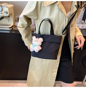 Détail du sac seau en nylon noir avec pendentif ours en peluche et logo BAH TOP