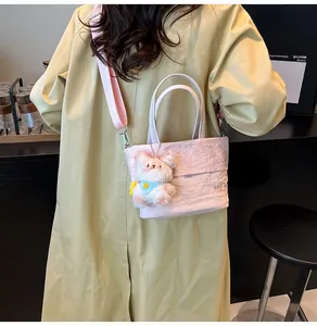 Détail du sac seau rose plissé avec pendentif ours en peluche et bandoulière