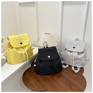 Detailed view of ultralight drawstring backpacks in yellow and checkered patterns