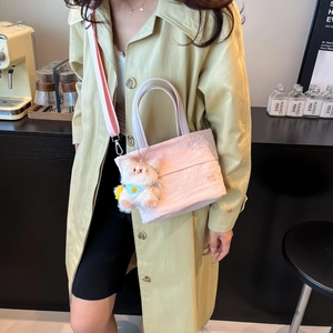 Sac seau rose décontracté en nylon avec large bandoulière et breloque ours dans un café