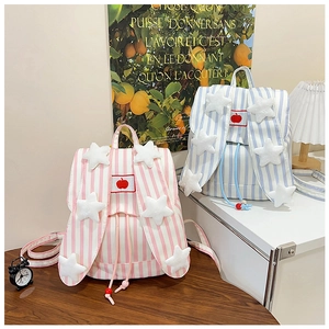 Detail of pink and blue striped canvas backpacks with cute bunny ears and apple embroidery