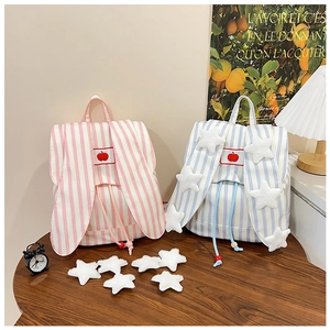 Striped canvas backpacks with cute bunny ears and red apple embroidery on a wooden table