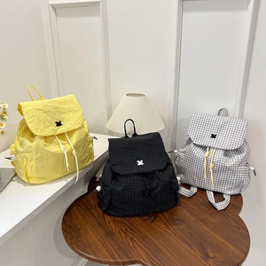 Lightweight drawstring backpacks in yellow and plaid patterns featuring a small animal logo