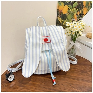 Close-up of rabbit ear canvas backpack with blue stripes and red apple embroidery