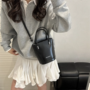 Minimalist black leather bucket bag with dual handles and fashion logo on the side