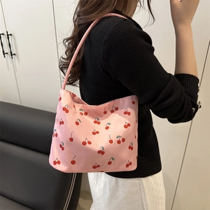 Sac seau rose avec imprimé cerises en nylon porté par un mannequin en vue latérale