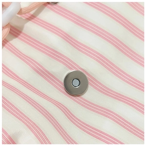 Detail of pink and white striped backpack with silver magnetic buckle and drawstring closure
