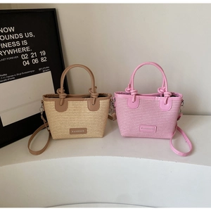 Detail of woven straw mini bags with knotted leather handles and fashion logo patch