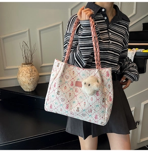 Detail of cute bear floral tote with pink braided leather handles and plush bear charm