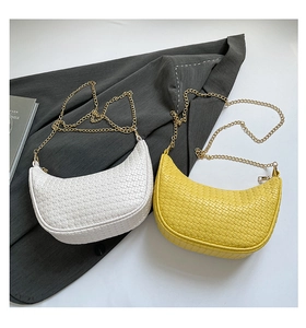 Detail of woven texture hobo bags in white and yellow with golden chain straps