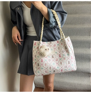 Detailed shot of floral tote bag with plush cloud charm and woven rope handles