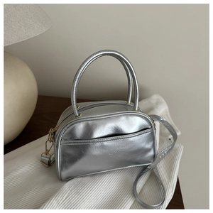Close-up of a silver Boston bag with golden hardware and textured metallic PU leather